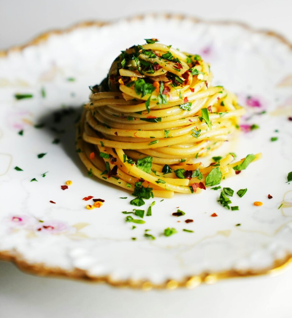 Elegant dish of Italian pasta with herbs on a decorative plate.