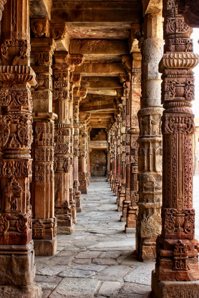 Explore the detailed stone carvings on historic architectural pillars in this ancient corridor.